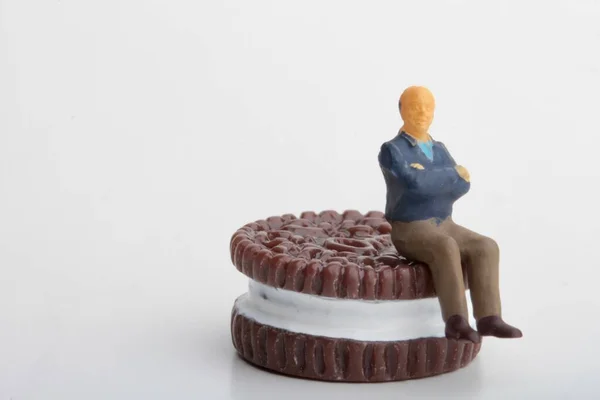 Miniature Figurine Man Sitting Huge Stuffed Biscuit — Fotografia de Stock