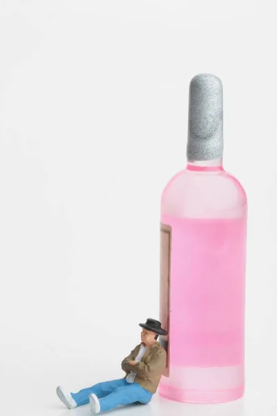Miniature Figurine Man Leaning Ros Wine Bottle — 스톡 사진