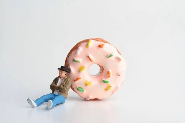 Miniature Figurine Sleeping Man Huge Donut White Background — Foto de Stock