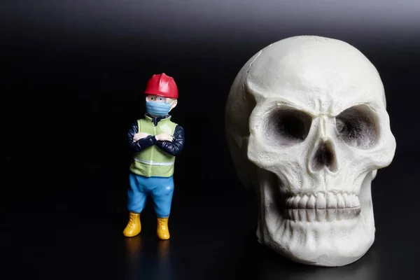 Estatueta Miniatura Homem Trabalho Com Crânio Humano Gigante Fundo Preto — Fotografia de Stock