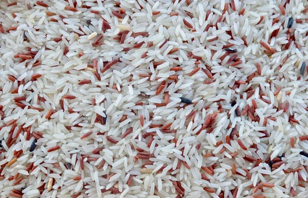 Cuisine and Food, Pile of Uncooked Brown and White Jasmine Long Rice, Basmati Rice or Thai Jasmine Rice. High in Vitamin B3, B6, B1 and B5.