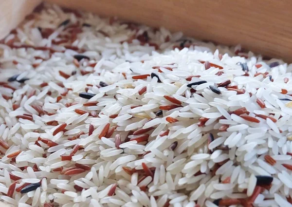 Cuisine and Food, Pile of Uncooked Brown and White Jasmine Long Rice, Basmati Rice or Thai Jasmine Rice. High in Vitamin B3, B6, B1 and B5.