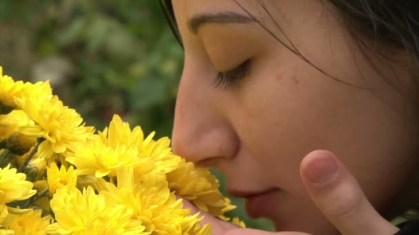 Garota adolescente cheirando flores — Stockvideo