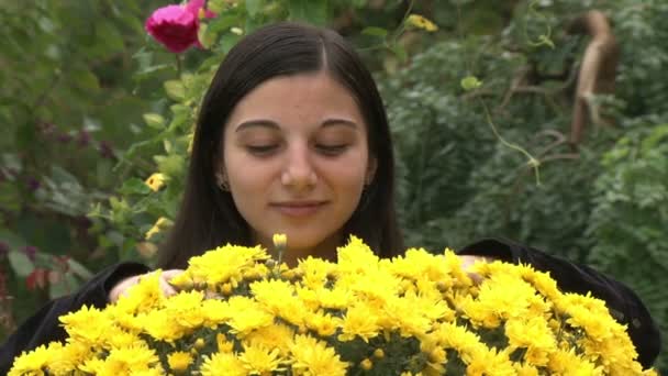 Garota adolescente cheirando flores — Stockvideo