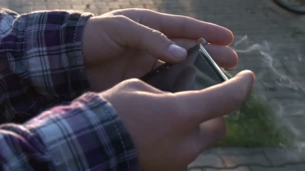 Homme utilisant smartphone et fumer 