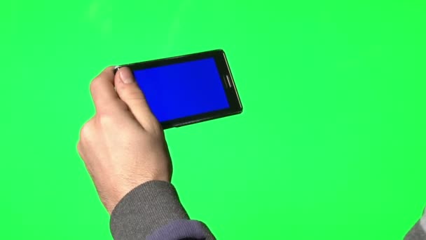 Hombre usando un teléfono inteligente con una pantalla azul para agregar su propio contenido personalizado — Vídeo de stock