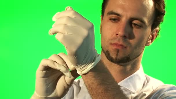 Arts opstijgen zijn chirurgische handschoenen - groen scherm — Stockvideo