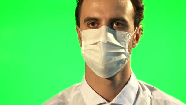 Врач надевает маску и хирургические перчатки - зеленый экран — стоковое видео