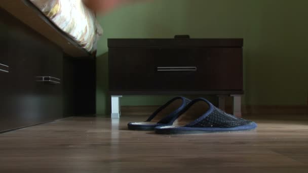 Male feet getting out of bed, put on slippers — Stock Video