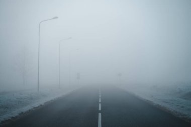 Boş şehir yolu sisle kaplı, sisli asfalt yol kış sabahı