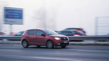 Riga, Letonya - 15 Kasım 2021: Red Dacia Sandero otoyolda hızlı sürüyor, hareket bulanıklığı var