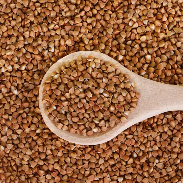 Semole di grano saraceno in un cucchiaio di legno — Foto Stock