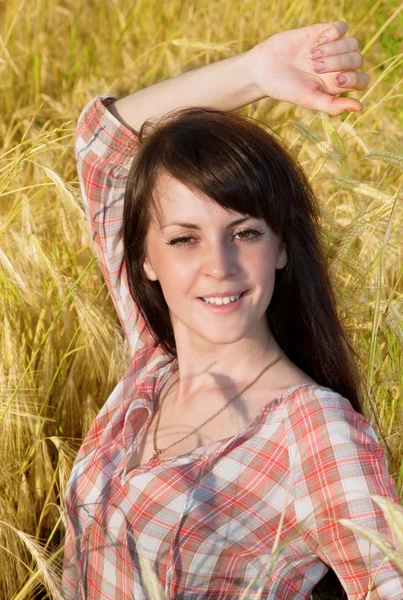 Mooie brunette in een veld — Stockfoto