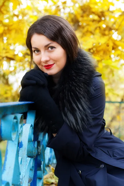 Beautiful woman sitting near the old railing — Stock Photo, Image