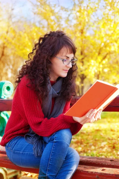Meisje het lezen van een boek in de herfst park — Stockfoto