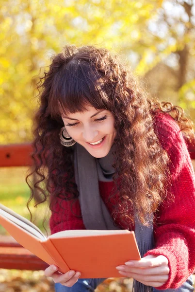 Chica leyendo un libro en el parque de otoño —  Fotos de Stock