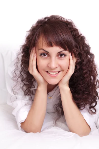 ベッドで横になっている白いシャツで美しい若い女性 — ストック写真
