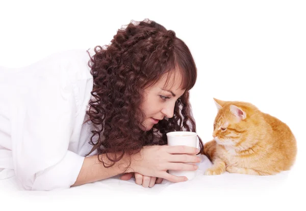 Flicka med en kopp kaffe och hennes katt i sängen — Stockfoto