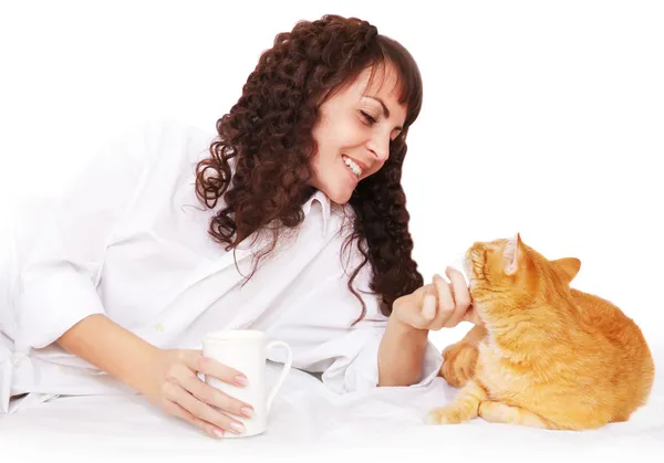 Meisje met een kopje koffie en haar kat in bed — Stockfoto