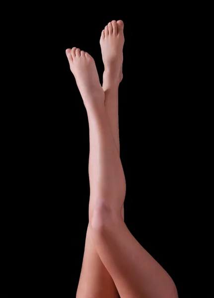 Smukłe nogi kobiece, na białym tle na czarnym tle — Zdjęcie stockowe