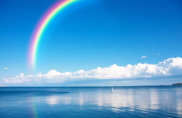 Rainbow üzerinde sonsuz su üzerinde mavi gökyüzü