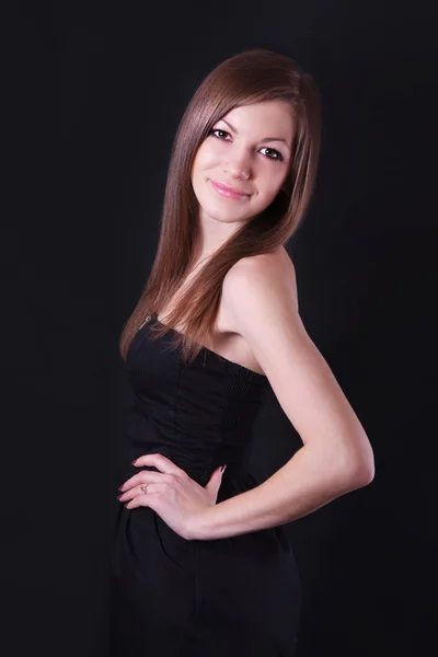 Portret van een mooie jonge vrouw in zwarte jurk — Stockfoto
