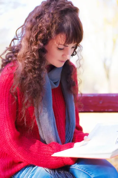 Chica leyendo un libro en el parque de otoño —  Fotos de Stock