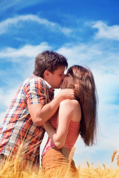 Beautiful couple kissing in wheat field — Stock Photo, Image