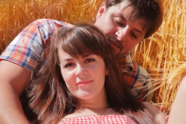 Man en vrouw omarmen in een veld — Stockfoto