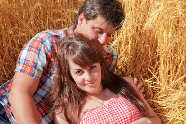 Man en vrouw omarmen in een veld — Stockfoto