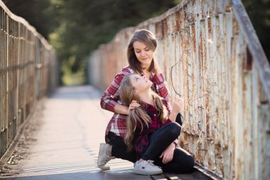Genç anne ve kızı güneşli bir günde yürüyüş yaparken eğleniyorlar. Neşeli duygular. 