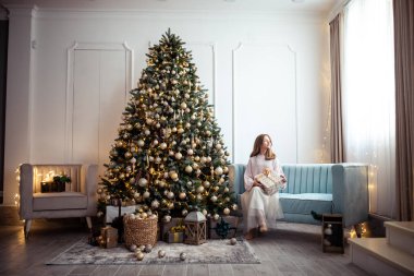 Süslü Noel ağacı olan bir odada tatlı bir genç kız. Kış tatili. Yüksek kalite fotoğraf