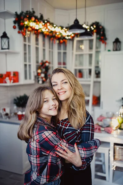 Mom and daughter in the kitchen. Winter holidays at home. Studio photo.