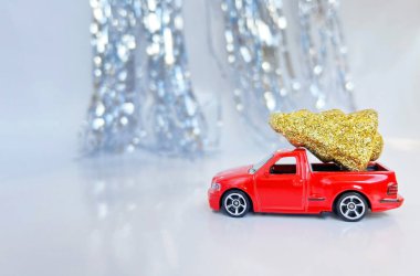 Noel ağacı taşıyan kırmızı bir araba. Yazılı pankartı olan. Noel için şenlikli, parlak arka plan