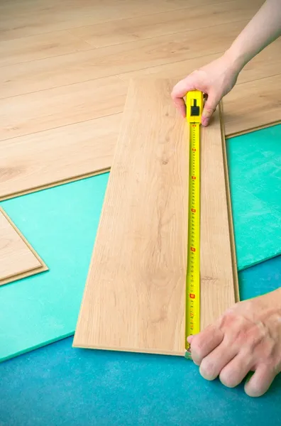 Javítása a padlóburkolatot. Ember intézkedés panel — Stock Fotó