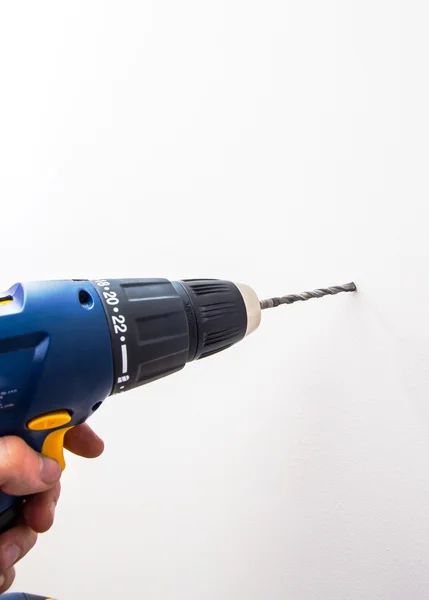 Mão de homem segurando broca azul — Fotografia de Stock