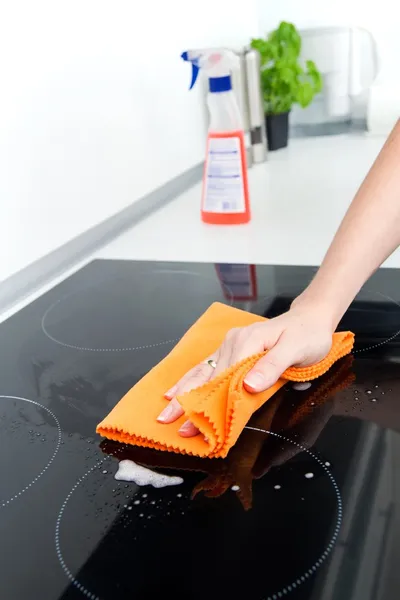 Hand cleaning induction stove — Stock Photo, Image