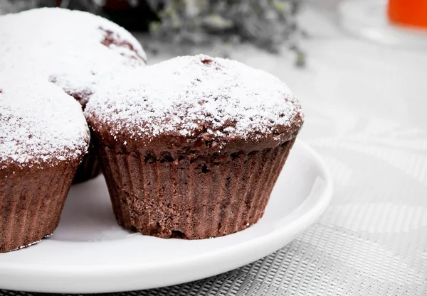 Chokladmuffins med socker på vit platta — Stockfoto