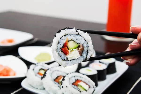 Hand holding sushi on sticks — Stock Photo, Image