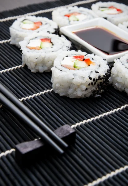 Sushi definido no tapete de bambu preto — Fotografia de Stock