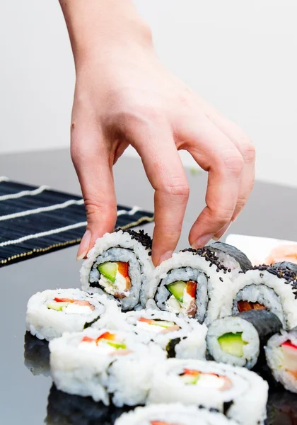 Hand holding sushi on black background — Stock Photo, Image