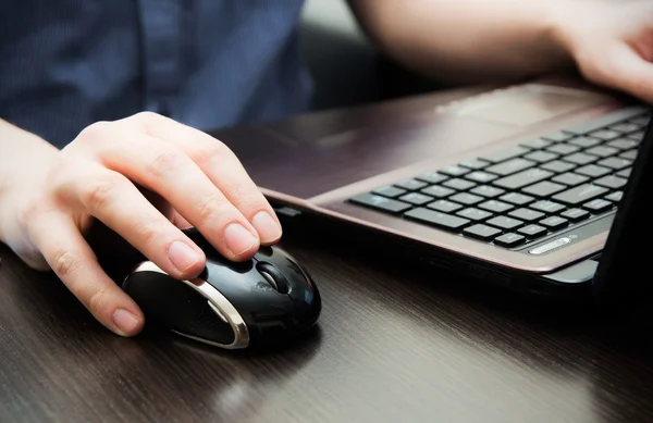 Menschliche Hand auf Computermaus. Laptop auf dem Schreibtisch. — Stockfoto