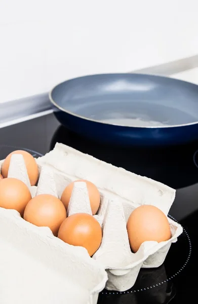 Яйця на індукційній плиті. Обсмажування сковороди на фоні — стокове фото