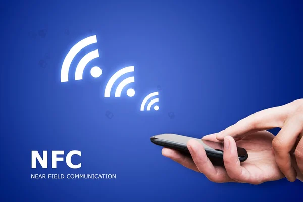 Mão segurando smartphone com tecnologia NFC perto de campo communi — Fotografia de Stock