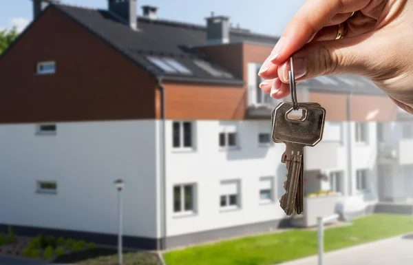 Mão de mulher segurando chaves para casa nova — Fotografia de Stock