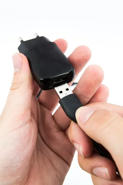 Člověk s použitím černé usb telefon nabíječka — Stock fotografie