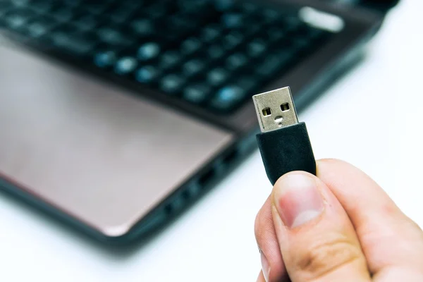 USB Tak tutan adam. arka planda laptop - Stok İmaj