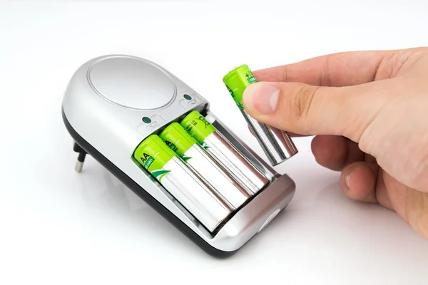 Mão tira bateria do carregador branco — Fotografia de Stock