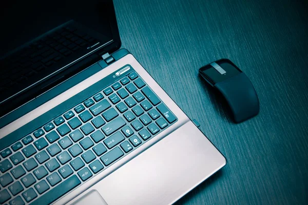 Laptop and modern flat mouse on wooden desk — Stock Photo, Image