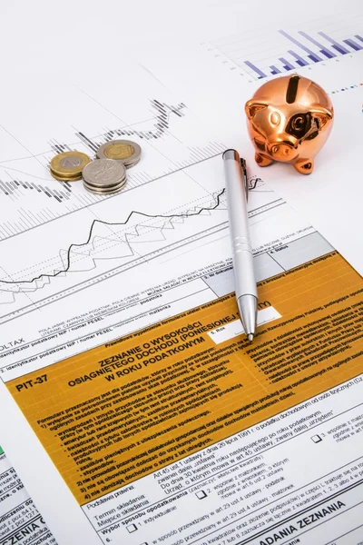 Pools inkomstenbelasting vormen met pen, munten en spaarpot — Stockfoto